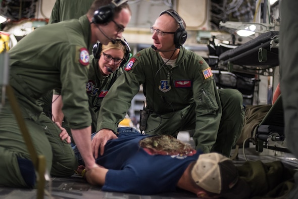 Staff Sgt. Avery Keller (front), second aeromedical evacuation technician, Staff Sgt. Sarah Bell (middle), charge medical technician, and Maj. Jeff Barley (right), medical crew director, all from the 137th Aeromedical Evacuation Squadron, Will Rogers Air National Guard Base, Oklahoma City, restrain a simulated patient, Senior Airman Andrew Dyer, 137th Special Operations Logistics Readiness Squadron from the same base, as he acts out an escape scenario during patient transportation aboard a C-17 Globemaster III from the 105th Airlift Wing, Stewart Air National Guard Base, N.Y., en route to Altus Air Force Base, Altus, Okla., Oct. 30, 2017. The flight was part of a wildfire scenario during Vigilant Guard, a North American Command-sponsored, state-wide emergency response exercise held Oct. 30 to Nov. 2, 2017. (U.S. Air National Guard photo by Staff Sgt. Kasey M. Phipps)