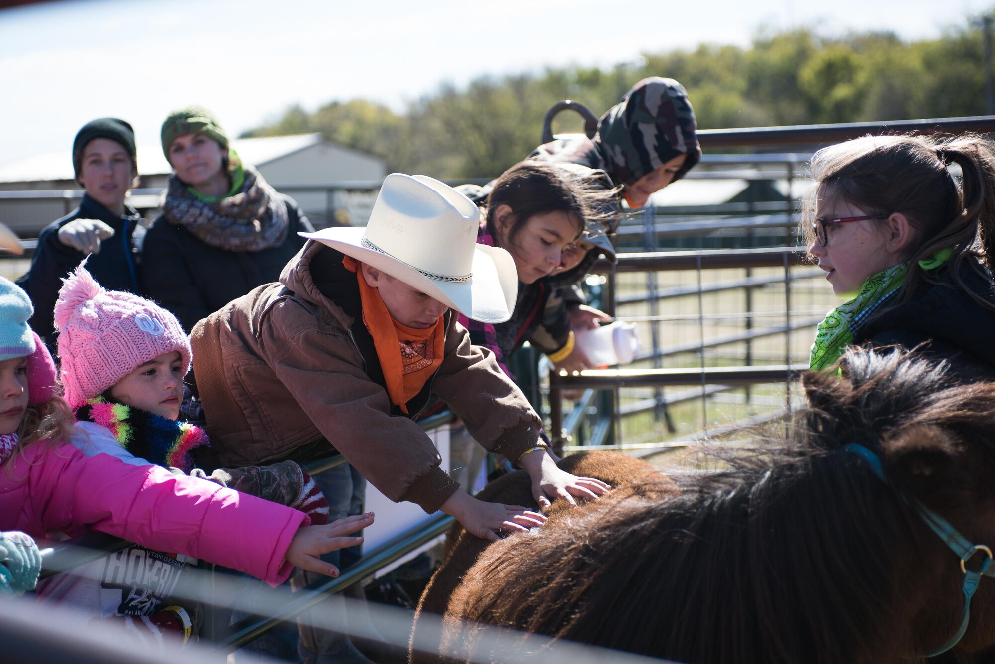 Children stretch over a fence to pet Brighty, a pony at the petting area hosted by the 4H Club, at the 6th Annual Oklahoma National Guard Adjutant General’s Horseback Heroes event, Oct. 28, 2017, at Covey Creek Ranch in Oklahoma City. Horseback Heroes is conducted each fall for military children to show support to the families of Guardsmen, especially those who are deployed. (U.S. Air National Guard photo by Staff Sgt. Kasey M. Phipps/Released)