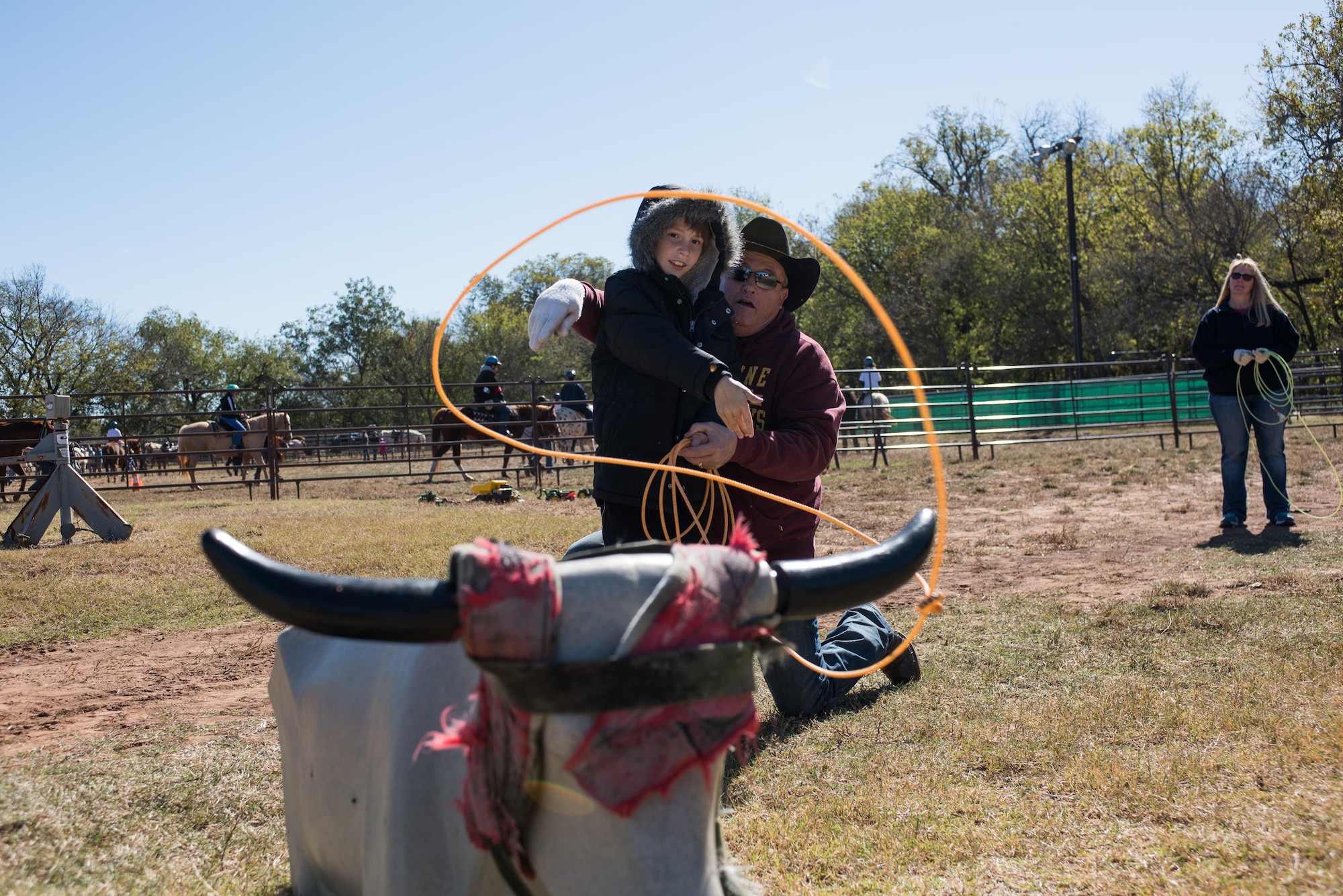 A roping instructor demonstrates proper roping techniques to a child at the 6th Annual Oklahoma National Guard Adjutant General’s Horseback Heroes event, Oct. 28, 2017, at Covey Creek Ranch in Oklahoma City. Horseback Heroes is conducted each fall for military children to show support to the families of Guardsmen, especially those who are deployed. (U.S. Air National Guard photo by Staff Sgt. Kasey M. Phipps/Released)