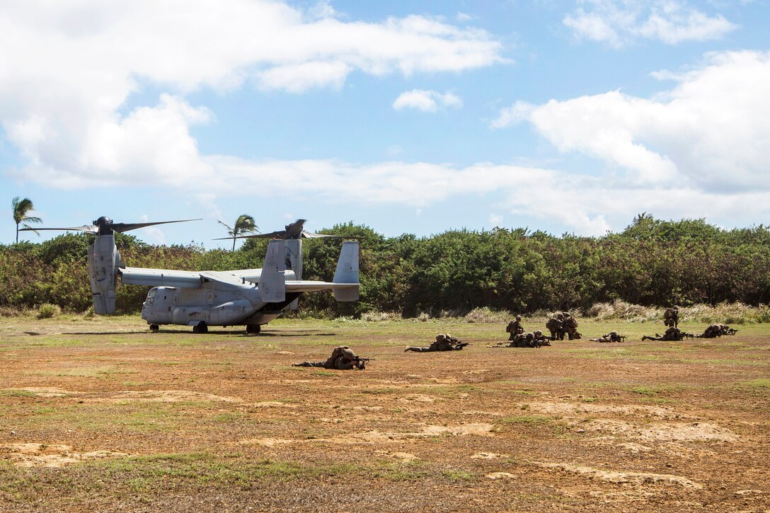 Marines set up a defensive perimeter around a MV-22B Osprey aircraft.