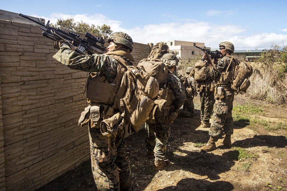 Marines maneuver through a military operations in urban terrain site during a tactical recovery of aircraft and personnel training event.