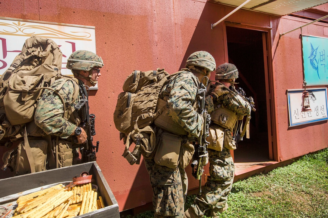 Marines clear a building in a military operations in urban terrain site as part of Exercise Bougainville II, at Landing Zone Boondocker, Marine Corps Base Hawaii,.