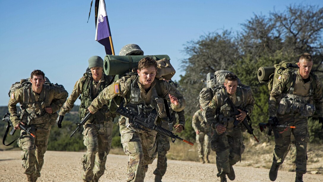 A row of ROTC cadets rush to the finish line.