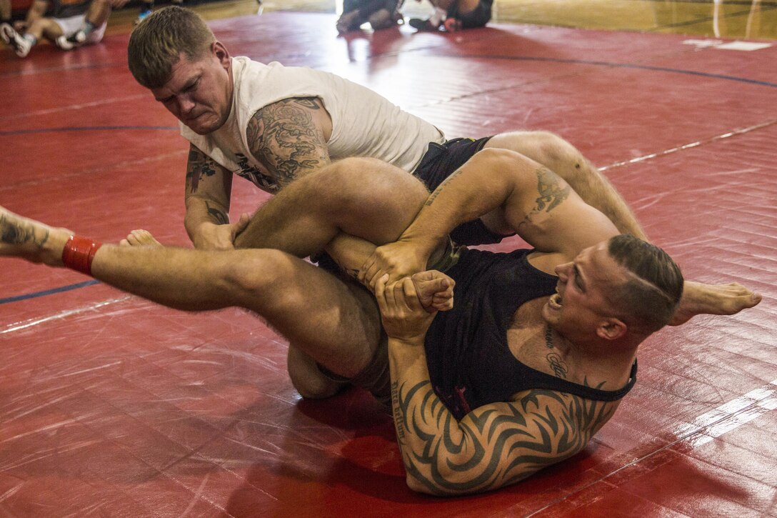 Two Marines grapple on a mat.