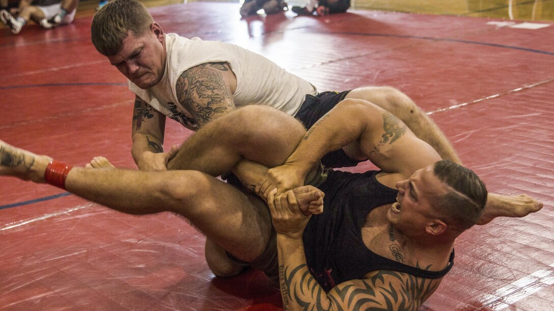 Two Marines grapple on a mat.