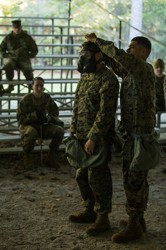 U.S. Marine Corps Cpl. David Mendez, right, a chemical, biological, radiological, nuclear defense specialist with the 26th Marine Expeditionary Unit (MEU), demonstrates the proper fitting of an M50 Joint Service General Purpose Mask during a CBRN training event at Marine Corps Base Camp Lejeune, N.C., Oct. 30, 2017.