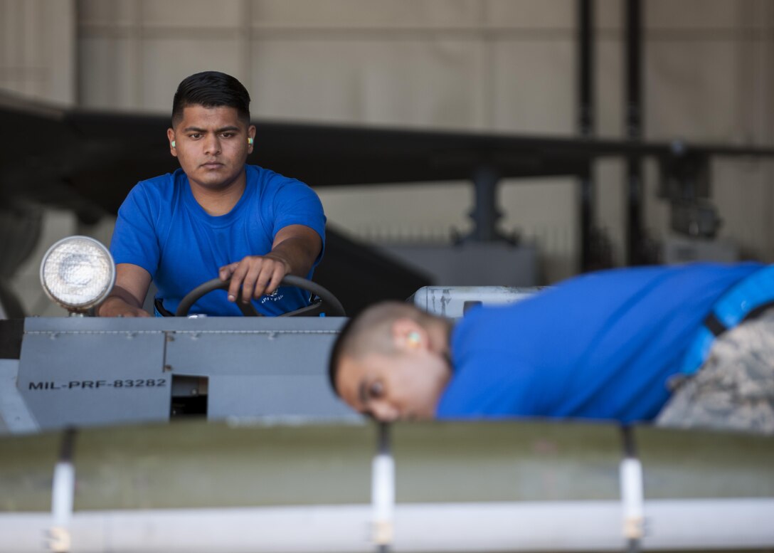 U.S. Air Force Senior Airman Shivanand Bissoon, and Staff Sgt. Princeleo Pecjo, 35th Air Munitions Squadron weapons load crew members, participate in a weapons load competition at Kunsan Air Base, Republic of Korea, Oct. 20, 2017. Load competitions showcase the skills and abilities of each Aircraft Maintenance Unit and prepare teams to load munitions as expeditiously and safely as possible to support Pacific Command priorities on the Korean Peninsula and within the region. (U.S. Air Force photo by Staff Sgt. Victoria H. Taylor)