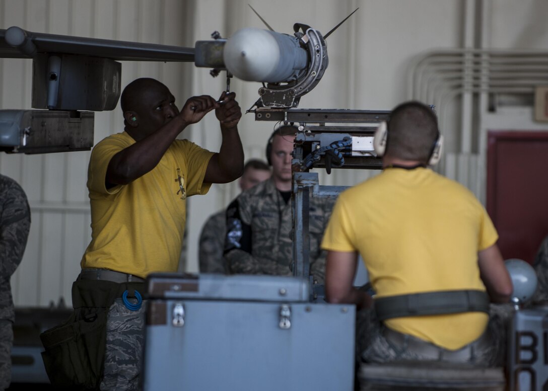 U.S. Air Force Staff Sgt. Marcus Knight, and Airman 1st Class Joshua Cartlidge, both 80th Aircraft Maintenance Unit weapons load crew members, participate in a weapons load competition at Kunsan Air Base, Republic of Korea, Oct. 20, 2017. The 8th Maintenance Group weapons standardization team hosted the competition to showcase the skills and abilities of each Aircraft Maintenance Unit as well as to promote espirit de corps. (U.S. Air Force photo by Staff Sgt. Victoria H. Taylor)