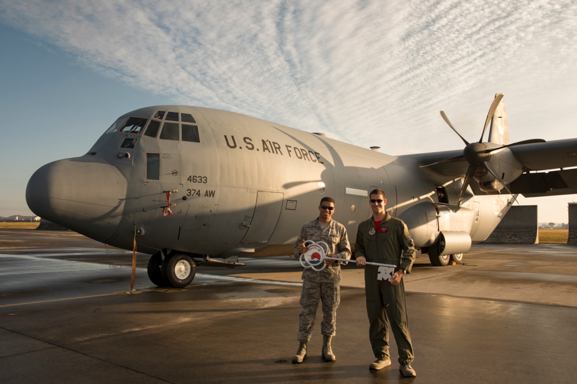 Staff Sgt. Rembert Dash, 374th Aircraft Maintenance Squadron crew chief, and Maj. George Metros, 36th Airlift Squadron C-130J instructor pilot, hold the ceremonial key in front of a C-130J Super Hercules at Yokota Air Base, Japan, Nov. 3, 2017.