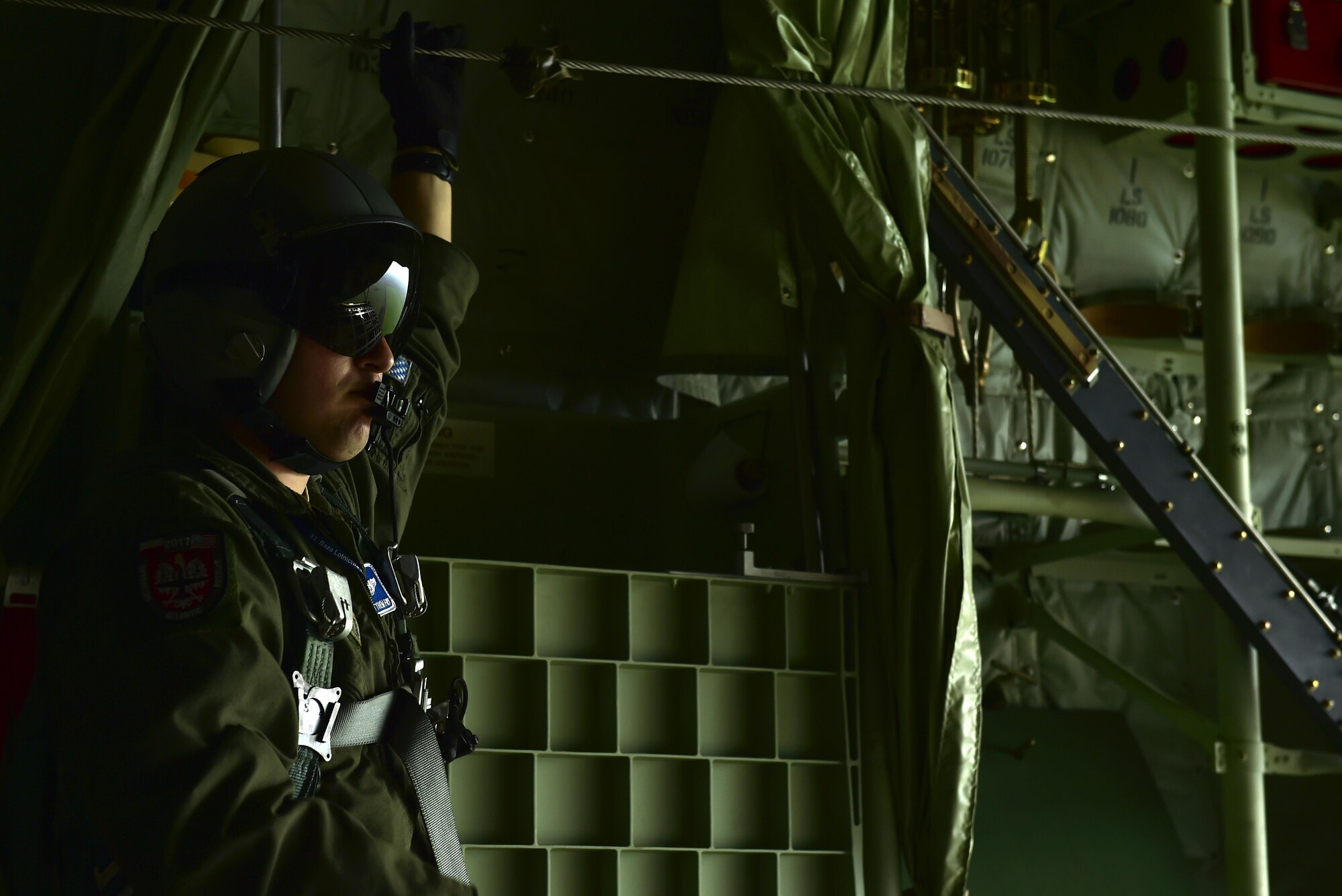 U.S. Air Force Staff Sgt. Matthew Fry, 37th Airlift Squadron loadmaster, stares out the rear cargo door of a C-130J Super Hercules during Operatin Atlantic Resolve over Poland, Oct. 16, 2017. The 37th AS aircrew practiced Air Interdiction Training against Polish Air Force MiG-29s. (U.S. Air Force photo by Staff Sgt. Jonathan Bass)