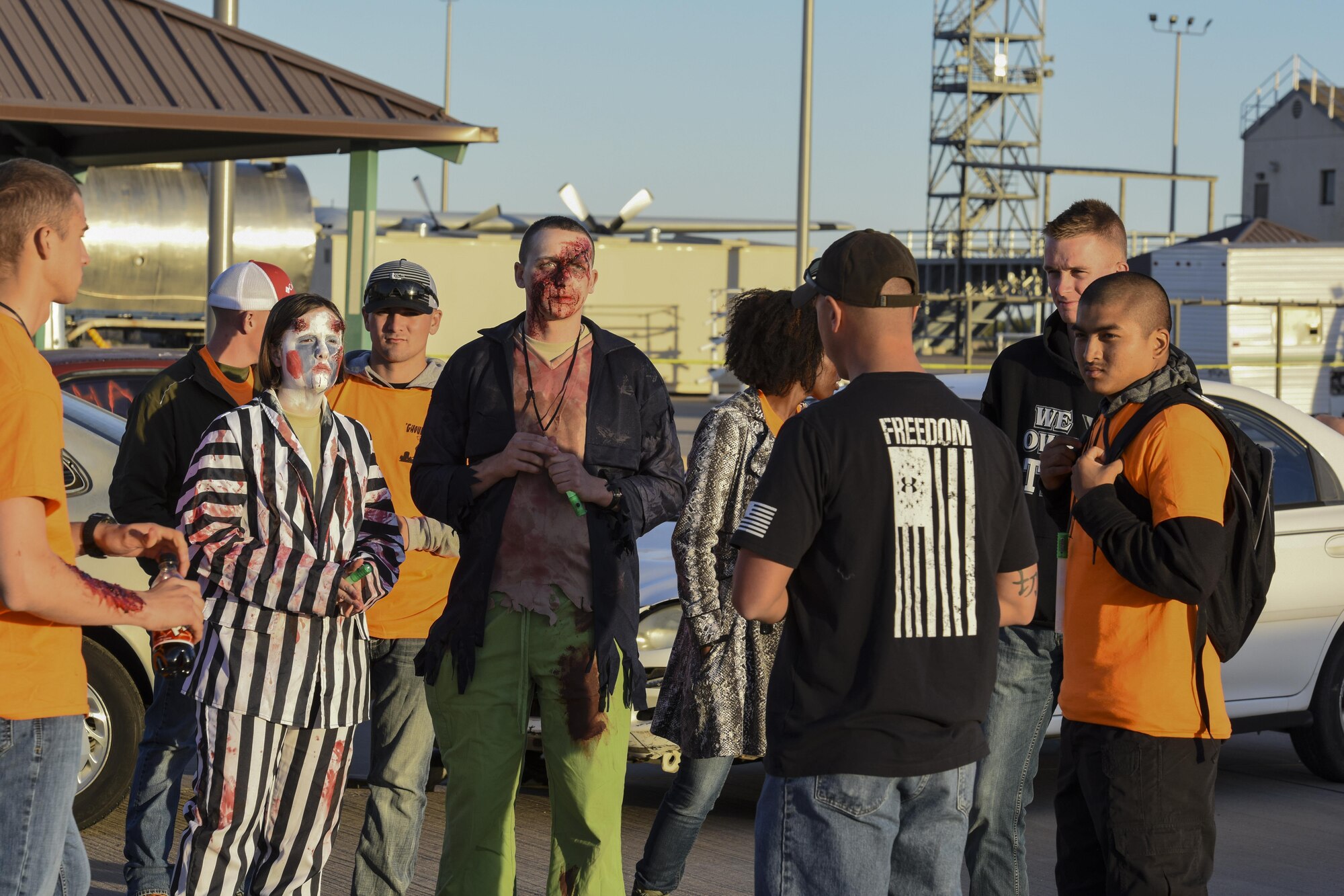 Volunteers stand by and receive a brief about their roles for the haunted house event during Ghoulfellow at Louis F. Garland Department of Defense Fire Academy on Goodfellow Air Force Base, Texas, Oct. 28, 2017. The fire training tower was a prop for the haunted house and was just one of the activities that took place during Ghoulfellow. (U.S. Air Force photo by Airman 1st Class Zachary Chapman/Released)