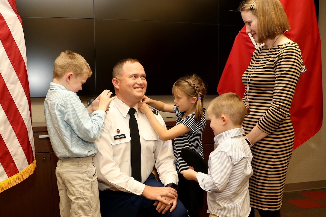 Maj. Christopher Burkhart, U.S. Army Corps of Engineers Nashville District deputy commander, enjoys the moment as his wife and children put on his new rank of lieutenant colonel during a promotion ceremony in Nashville, Tenn., Nov. 2, 2017. (USACE photo by Mark Abernathy)