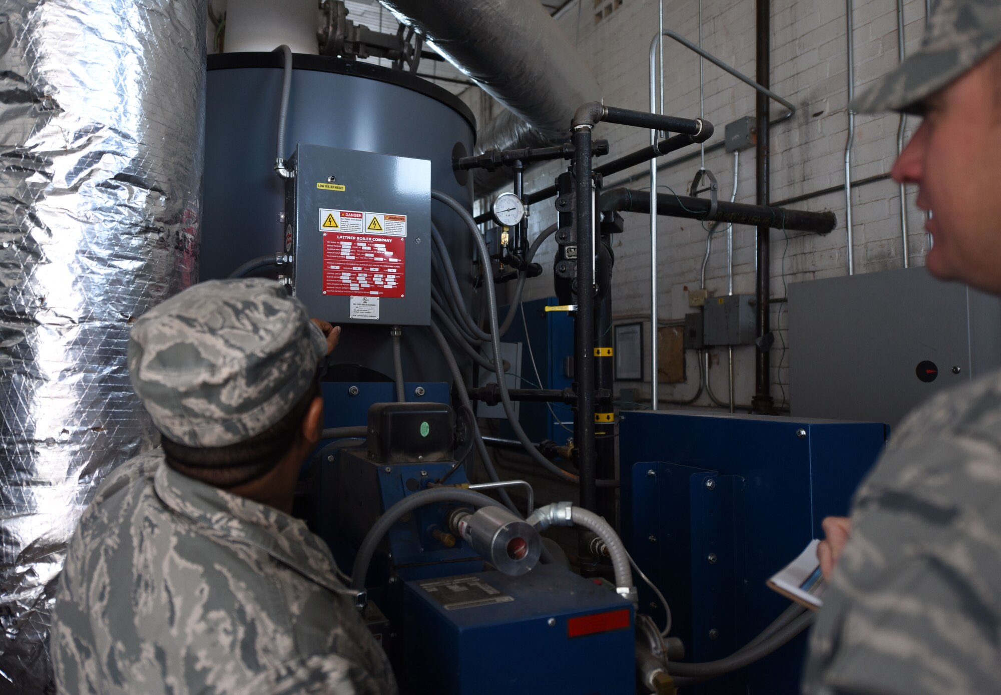 Tech. Sgt. Grahame Evelyn, 90th Civil Engineering Squadron heating ventilation air conditioning technician, gives Tech. Sgt. Charles Hernandez data to write in the log, on F.E. Warren Air Force Base Wyo., Oct. 31 2017. The data is used to track trends to find root causes that are affecting large systems such as hard water or corrosion in old pipes, causing HVAC systems to fail. (U.S. Air Force Photo by Airman 1st Class Braydon Williams)