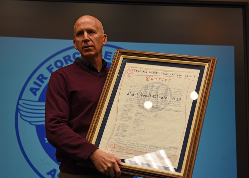 Cary Hatzinger, former 62nd Airlift Wing command chief and current senior advisor of the Chief Master Sgt. Thomas N. Barnes Air Force Sergeants Association Chapter 1461, speaks to students at the Julius A. Kolb Airman Leadership School at McChord Field prior to presenting the chapter’s original hand-scribed charter to Master Sgt. Kenneth Markline, ALS commandant, Oct. 31, 2017.