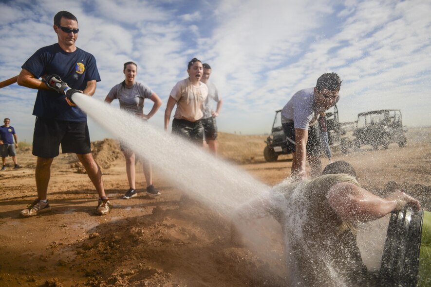Arizona State University ROTC cadets cheer on their teammate during the 4th annual Luke Mudder at Luke Air Force Base, Ariz., Nov. 3, 2017. Working in teams of four, cadets competed for the fastest time in finishing the 17 obstacle, mile and a half course. (U.S. Air Force photo/Airman 1st Class Caleb Worpel)