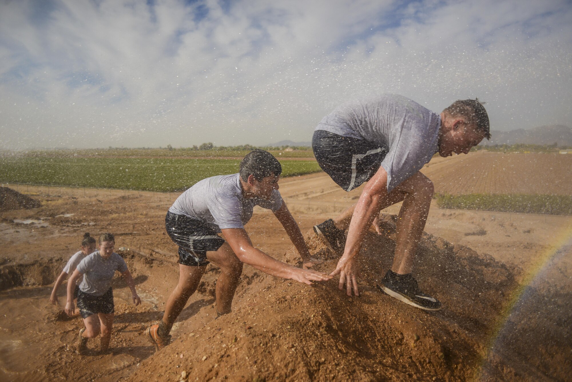 Bryce Mellish, Arizona State University ROTC cadet, swims through a mud trench during the 4th annual Luke Mudder at Luke Air Force Base, Ariz., Nov. 3, 2017. The event was an opportunity for cadets to close their books, get outside, connect with other detachments and start learning about Air Force lifestyle. (U.S. Air Force photo/Airman 1st Class Caleb Worpel)
Arizona State University ROTC cadets scale an obstacle during the 4th annual Luke Mudder at Luke Air Force Base, Ariz., Nov. 3, 2017. Working in teams of four, cadets competed for the fastest time in finishing the 17 obstacle, mile and a half course. (U.S. Air Force photo/Airman 1st Class Caleb Worpel)