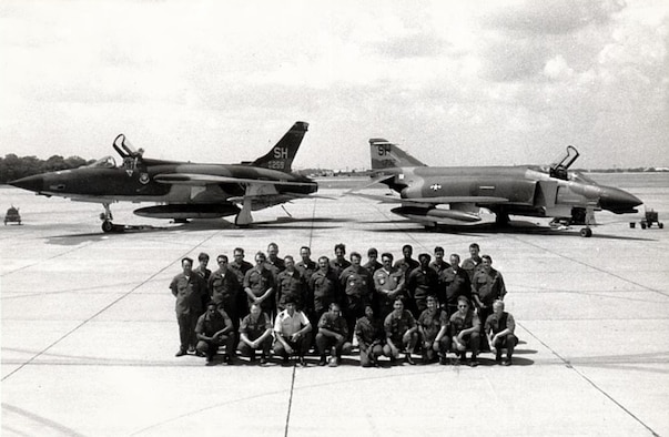 Members of the 507th Tactical Fighter Group pose for a unit photo in front of the F-105 Thunderchief and F-4 Phantom II during the unit conversion at Tinker Air Force Base, Okla. In 1980, the 507th TFG Okies were re-equipped with the McDonnell Douglas “Mig Killer” F-4D fighter aircraft. (U.S. Air Force Photo)
