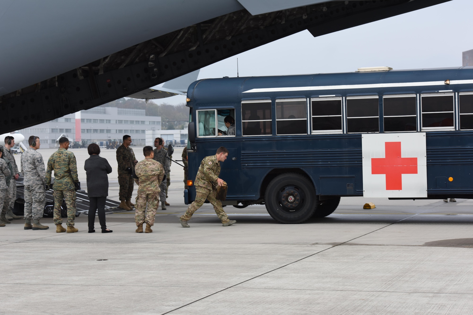 A volunteer for the En-route Patient Staging program prepares to place a block underneath the tire of a medical bus on the flightline of Ramstein Air Base, Germany, Oct. 26, 2017. ERPS uses buses to transport injured service members from Landstuhl Regional Medical Center to Ramstein’s airfield.