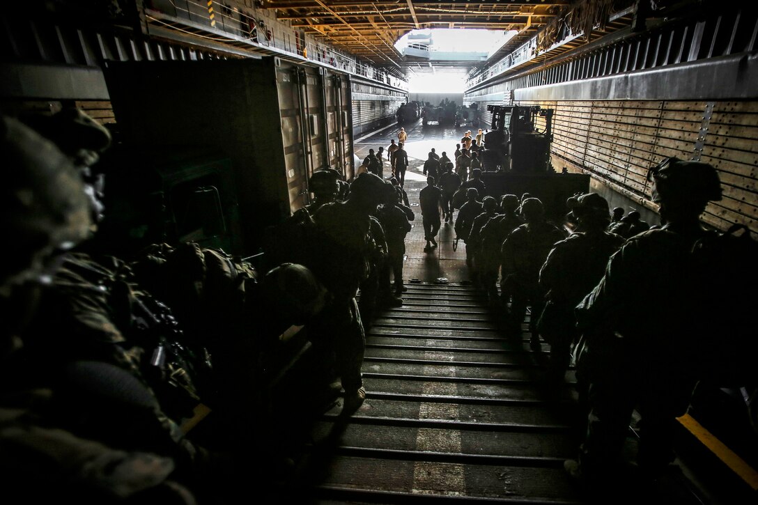 Marines move in the well deck of the USS Ashland before participating in an amphibious landing during exercise Blue Chromite 18 at Kin Blue Beach in Okinawa, Japan.