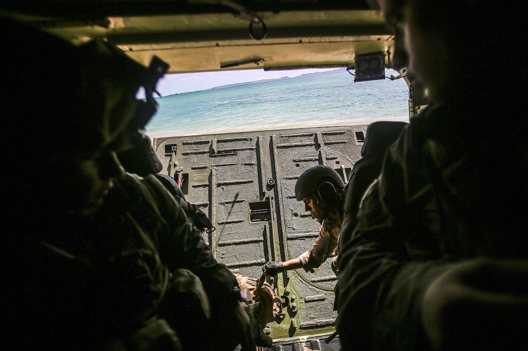 A Marine opens the back door to an amphibious assault vehicle during exercise Blue Chromite 18 at Kin Blue Beach in Okinawa, Japan.