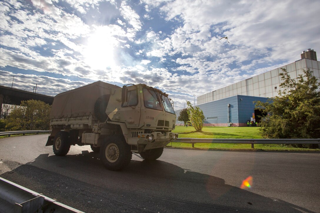 Soldiers drive tactical vehicles loaded with prescription drugs to the Covanta Essex Resource Recovery Facility.