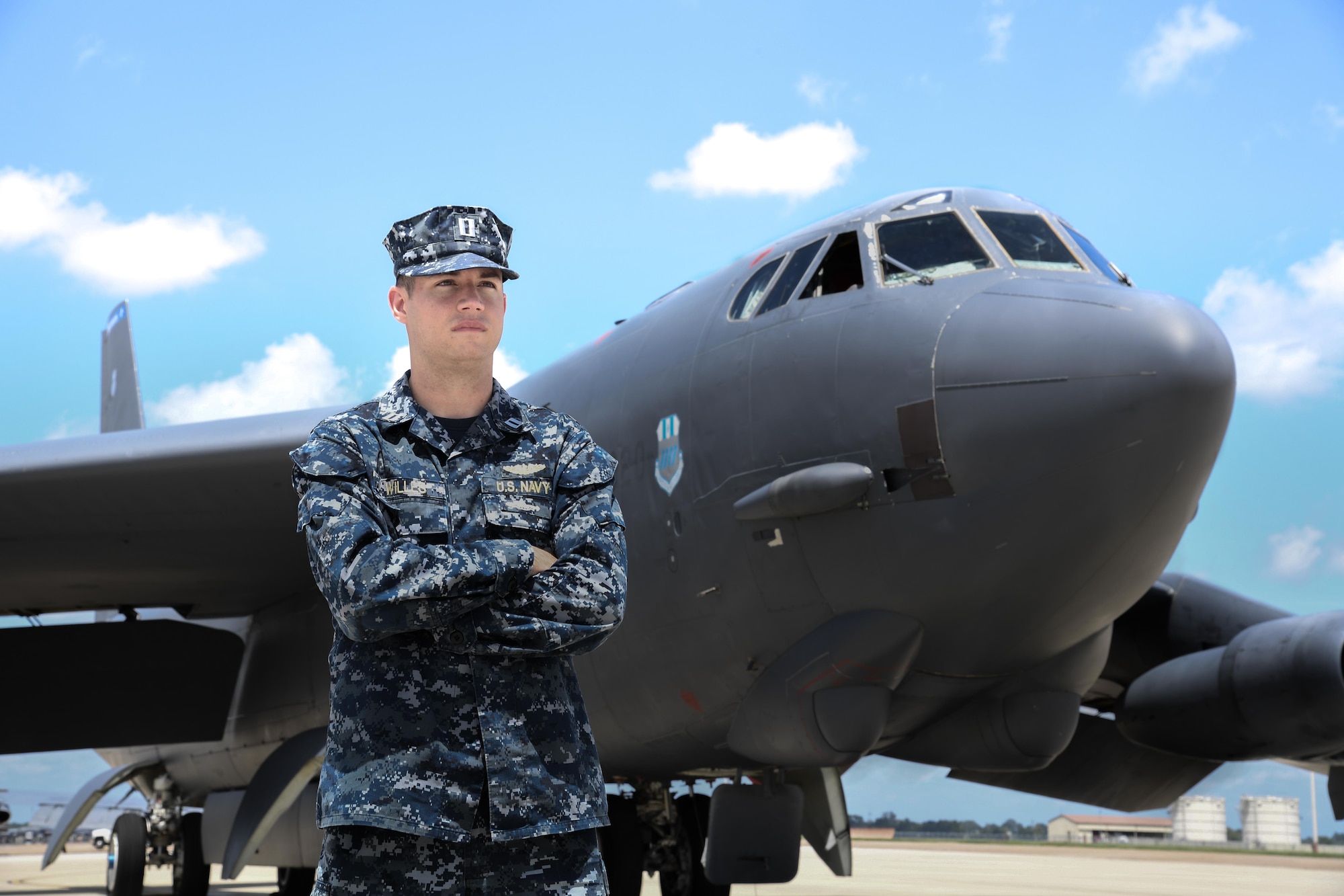 U.S. Navy Lt. Andrew Willes stands in front of a B-52 on a flightline at Barksdale AFB, Louisiana.