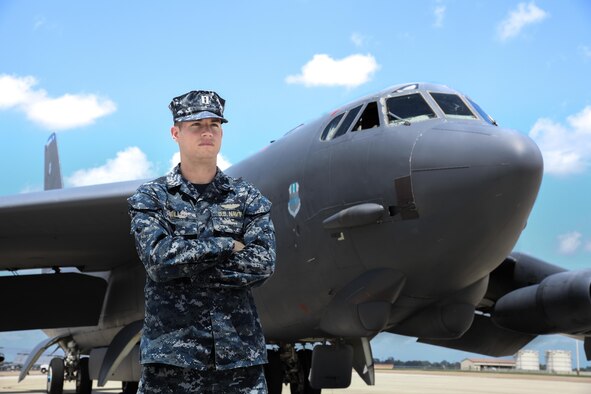 U.S. Navy Lt. Andrew Willes stands in front of a B-52 on a flightline at Barksdale AFB, Louisiana.
