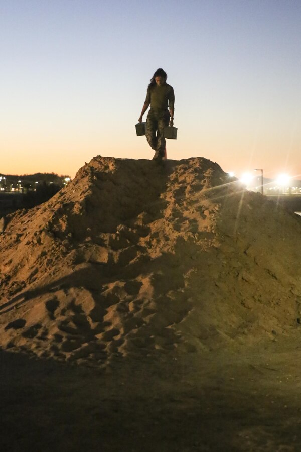 A Marine with Alpha Company, Headquarters Battalion, conducts an ammunition can carry during a company-wide physical training event at Del Valle Field aboard the Marine Corps Air Ground Combat Center, Twentynine Palms, Calif., October 27, 2017. The training was held as a competition to reinforce unit cohesion and camaraderie among the Marines of Alpha Company. (U.S. Marine Corps photo by Pfc. Margaret Gale)