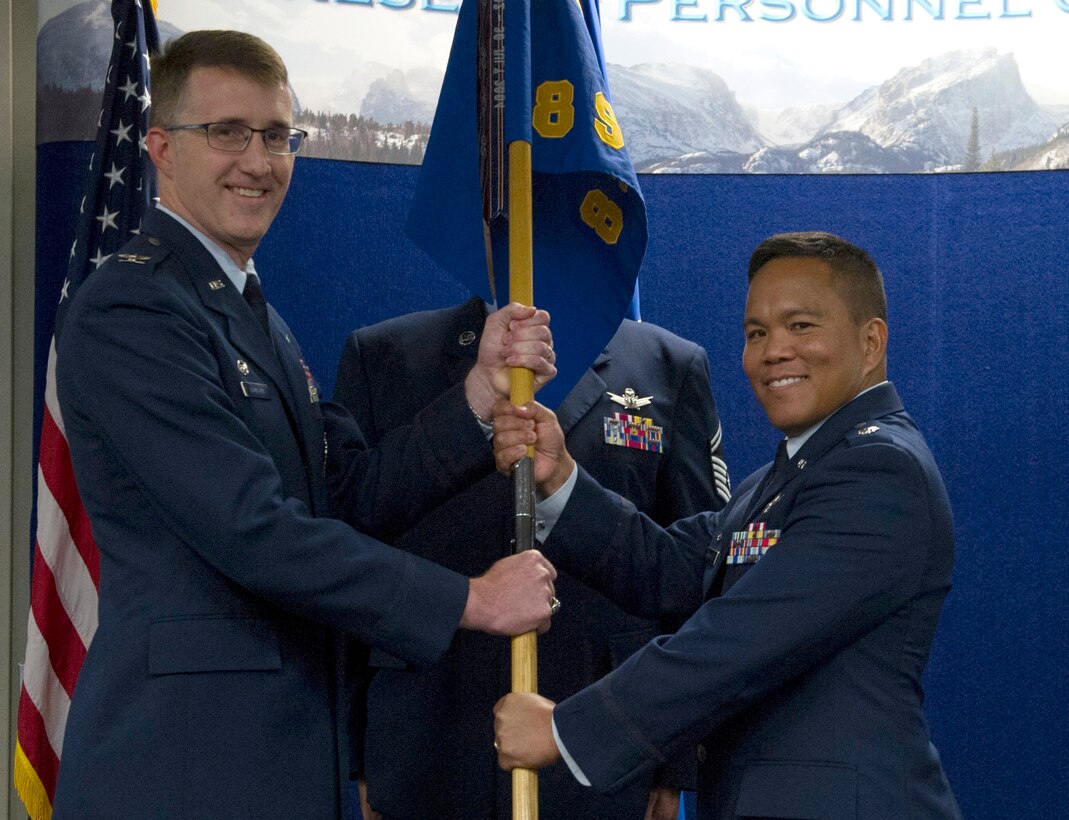 Col. Daniel Bourque, 710th Operations Group commander, passes the 8th Space Warning Squadron guidon to incoming 8 SWS commander, Lt. Col. James Mindoro during the Assumption of Command ceremony at Buckley AFB on Saturday, Nov. 4, 2017.