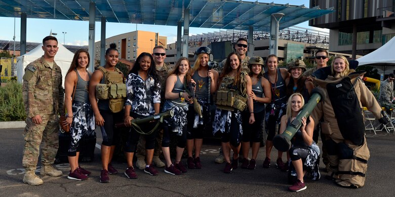 Members of the Arizona State University Women’s Gymnastics team and the 56th Civil Engineer Squadron explosive ordnance disposal unit pose for a group photo during ASU’s annual Salute to Service tailgate event in Tempe, Ariz., Nov. 4, 2017. The 56th CES EOD displayed equipment used for their job and explained how they contribute to the base mission of building the future of Airpower. (U.S. Air Force photo/Senior Airman Devante Williams)