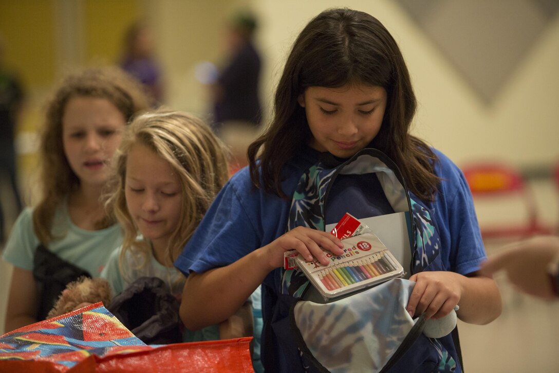 A Foster Girl Scout waits in line to fill up a backpack with donations