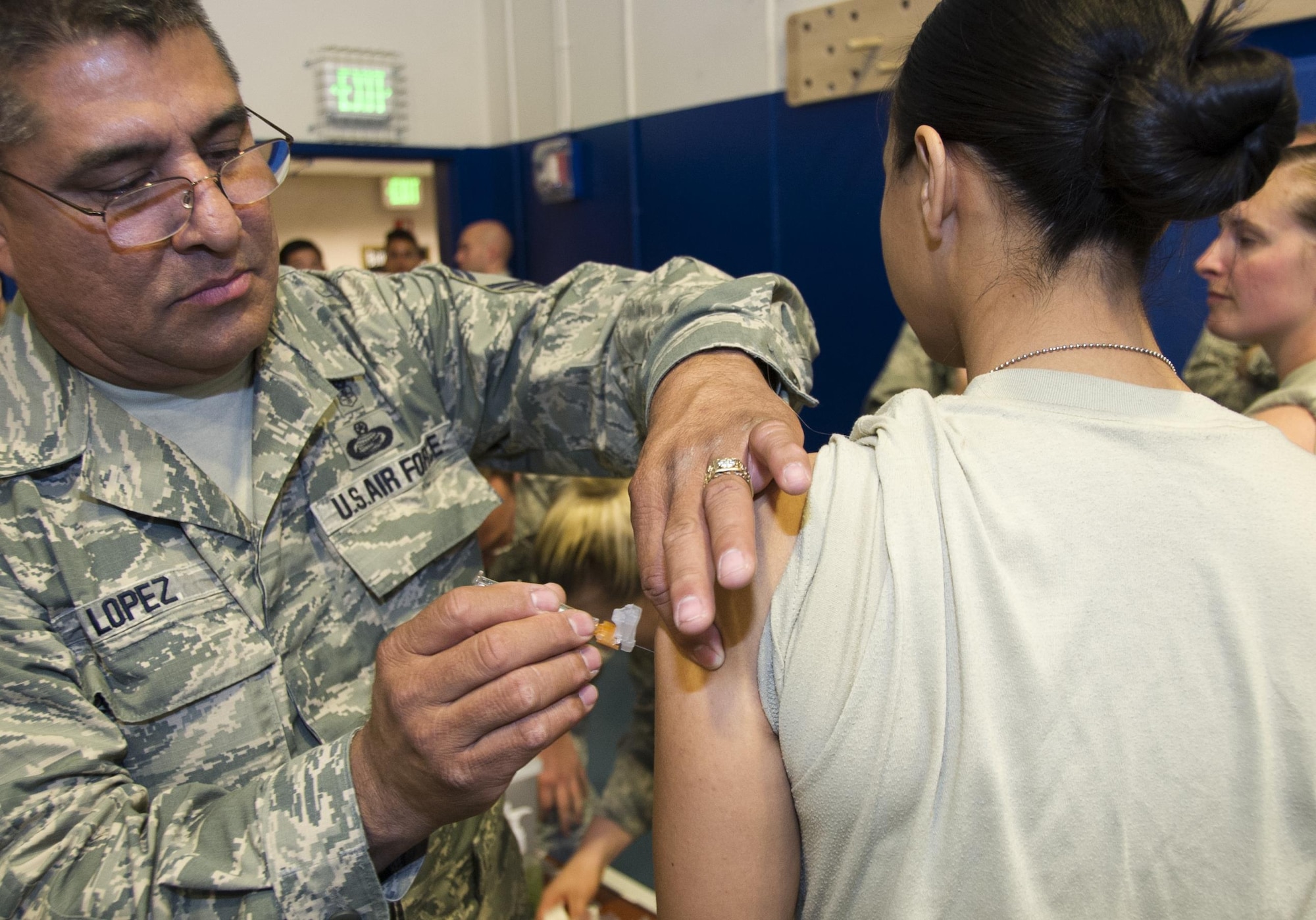 Senior Master Sgt. Esteban Lopez, 310th Aerospace Medicine Flight, administers the flu shot to Staff Sgt. Monica Arana, 310th Force Support Squadron, at the 310th Space Wing's commander's call on Sunday, Nov. 5, 2017.
