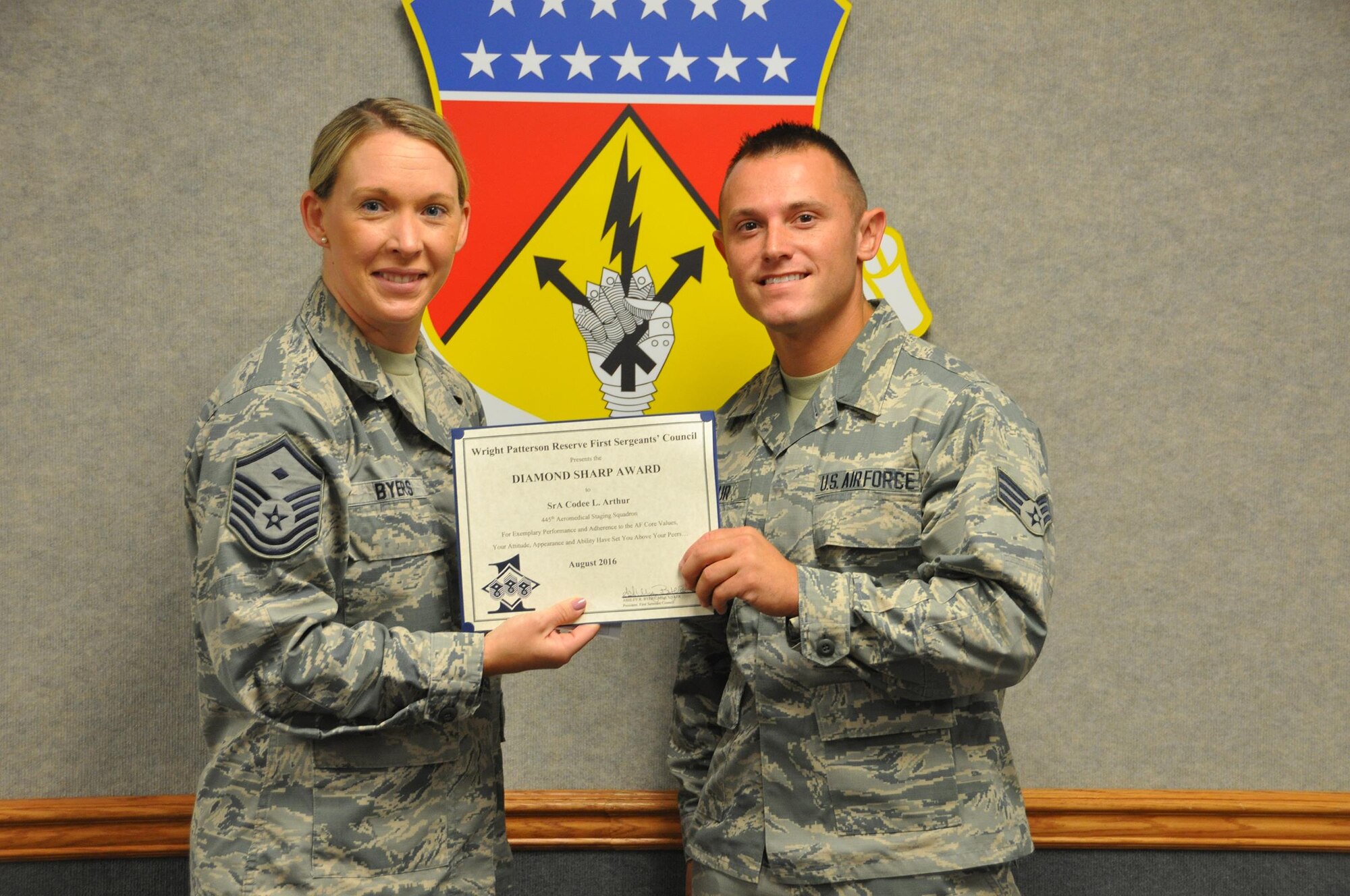 Master Sgt. Ashley Byers, 64th Intelligence Squadron first sergeant, presents the August 2017 Diamond Sharp Award to Senior Airman Codee Arthur, 445th Aeromedical Staging Squadron, Oct. 14, 2017