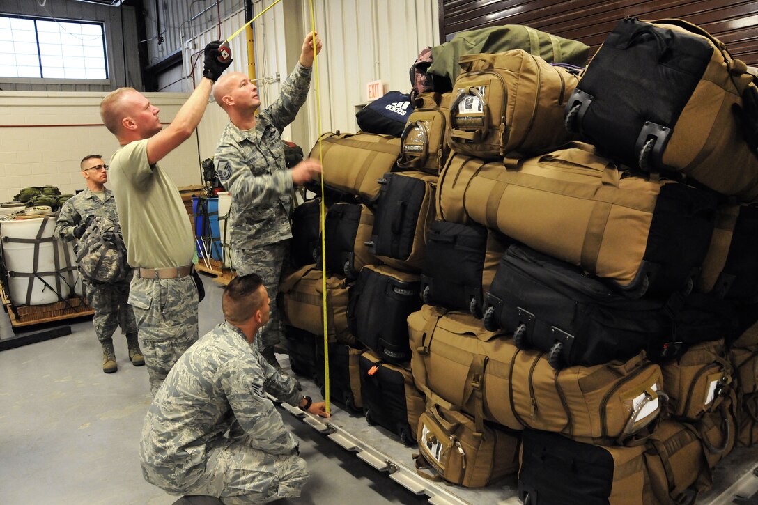 National Guardsmen measure a pallet containing luggage.