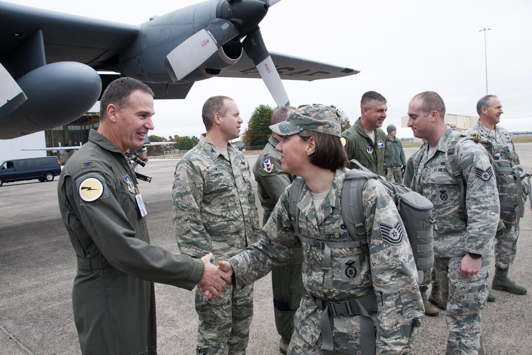 Air National Guard leaders shake hands with airmen.