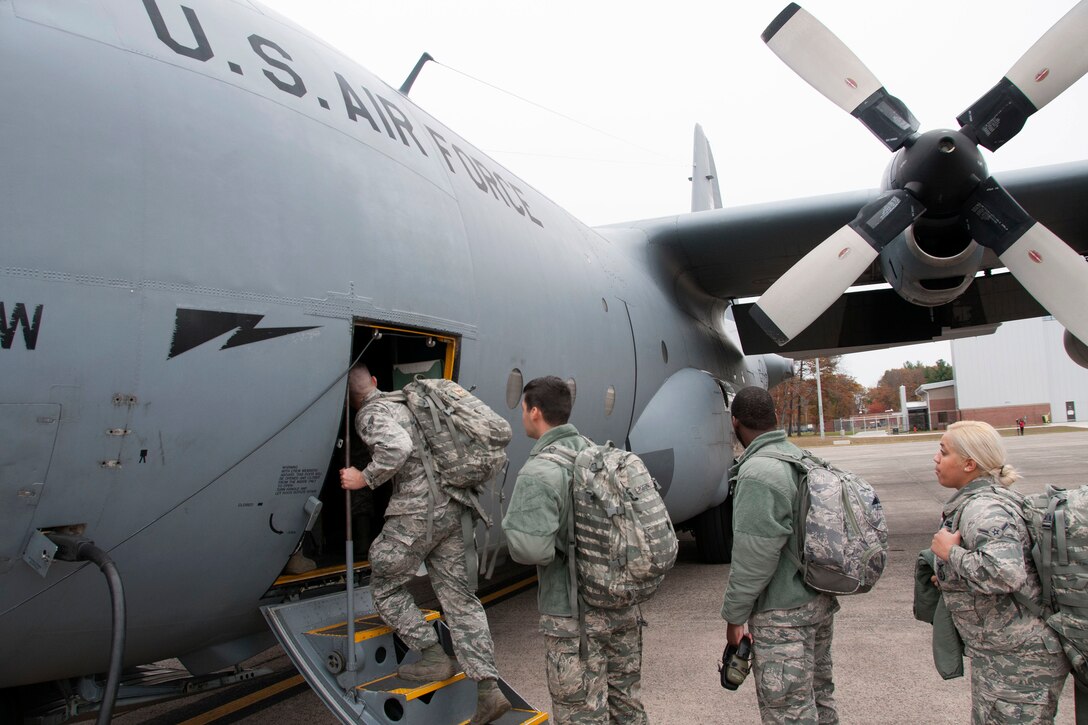 Massachusetts and Connecticut Air National Guardsmen board a C-130 Hercules aircraft.