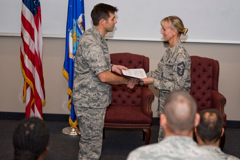 U.S. Air Force Reserve Col. Christopher T. Lay, commander, 913th Airlift Group, presents Chief Master Sgt. Kimberly Lord, superintendent, 913 AG, a congratulations certificate during her promotion ceremony at Little Rock Air Force Base, Ark., Nov. 3, 2017.