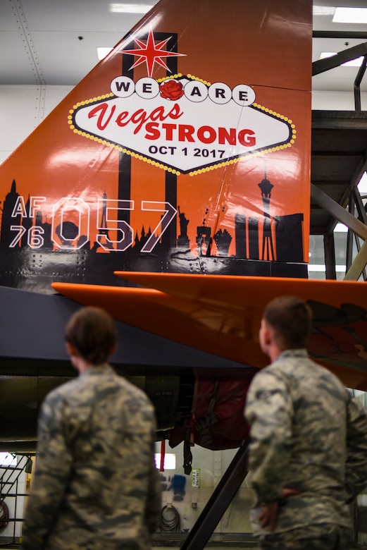 Senior Airmen Brittany Galloway and Dillon Cutlip, 57th Wing creative design team members, observe their final product on the tail of an F-15C Eagle at Nellis Air Force Base, Nevada, Nov. 1, 2017. The aircraft is being repainted to recognize the Air Force's 70th Anniversary as well as the unity between the Las Vegas community and Nellis AFB. (U.S. Air Force photo by Airman 1st Class Andrew D. Sarver/Released)
