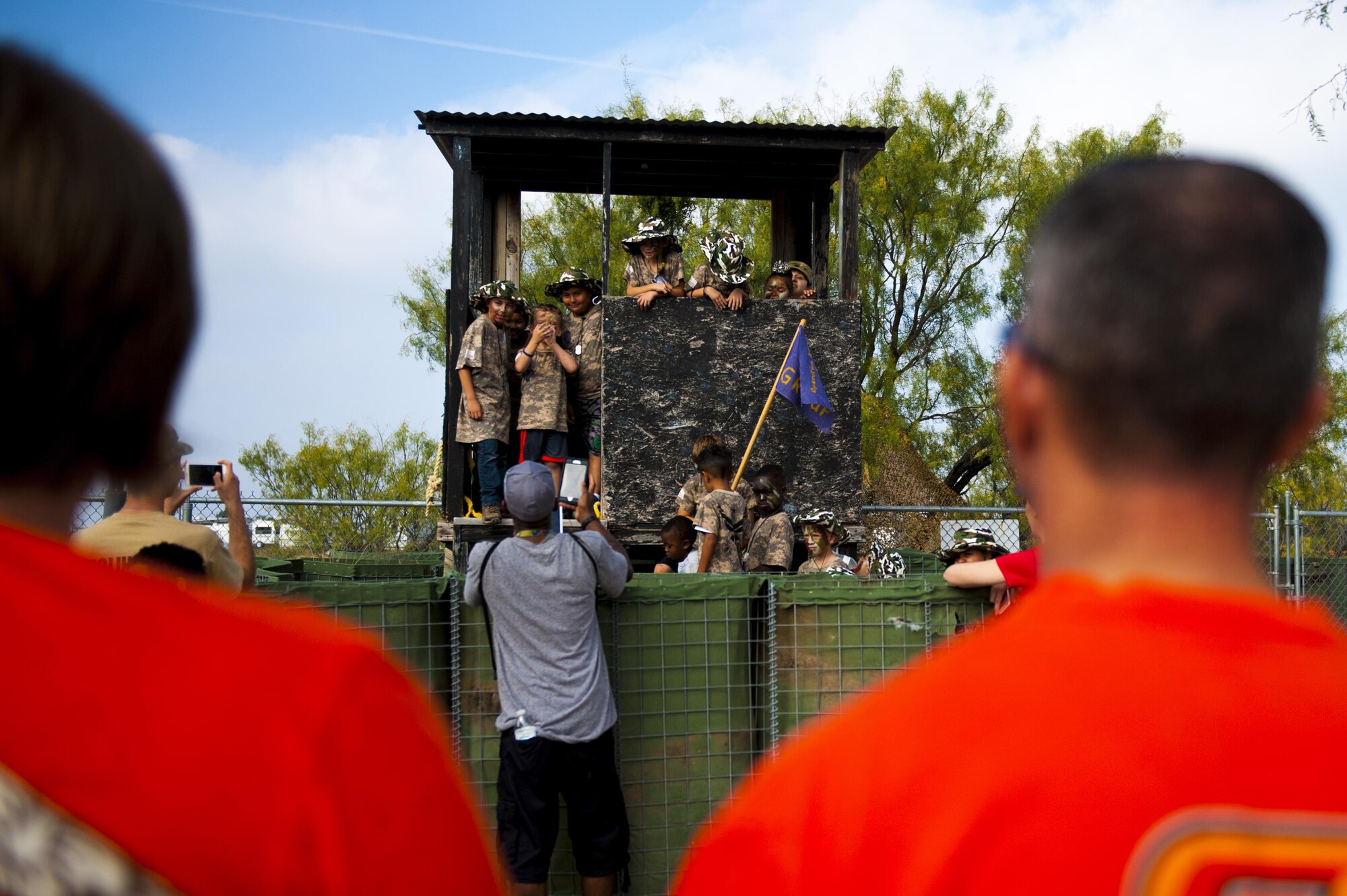 U.S. Air Force Lt. Col. Scott Cline, 312th Training Squadron commander, watches his kids participate in an obstacle course during Operation Kids Investigation Deployment Services at the Afghan Village on Goodfellow Air Force Base, Texas, Nov. 4, 2017. The 17th Force Support Squadron and base volunteers hosted the event, coordinating with each other. (U.S. Air Force photo by Senior Airman Scott Jackson/Released)