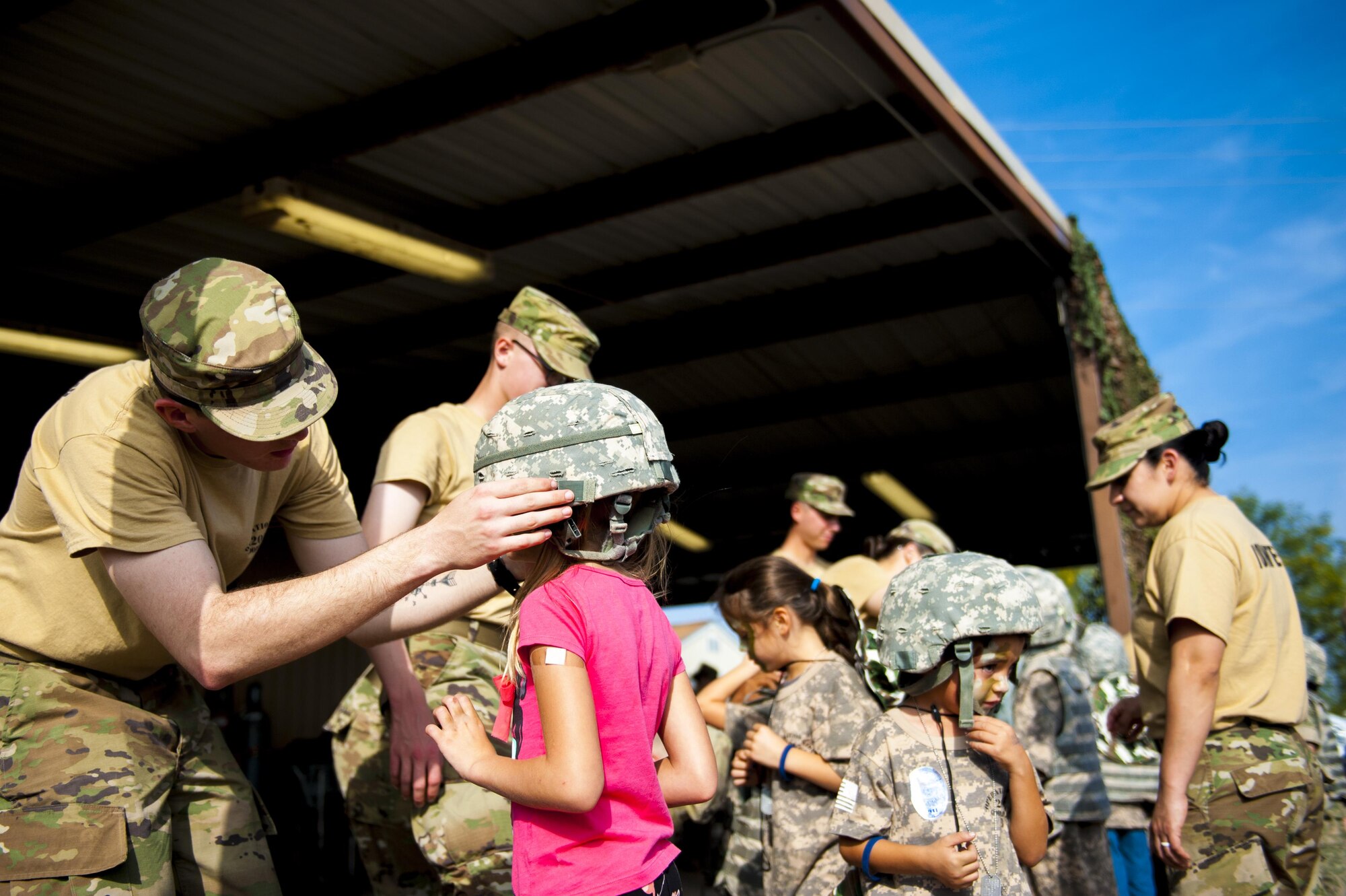 Volunteers assist participants of Operation Kids Investigating Deployment Services don helmets at the Afghan Village of Goodfellow Air Force Base, Texas, Nov. 4, 2017. This was the largest iteration of Operation KIDS with 100 children from the base and local community participating. (U.S. Air Force photo by Senior Airman Scott Jackson/Released)