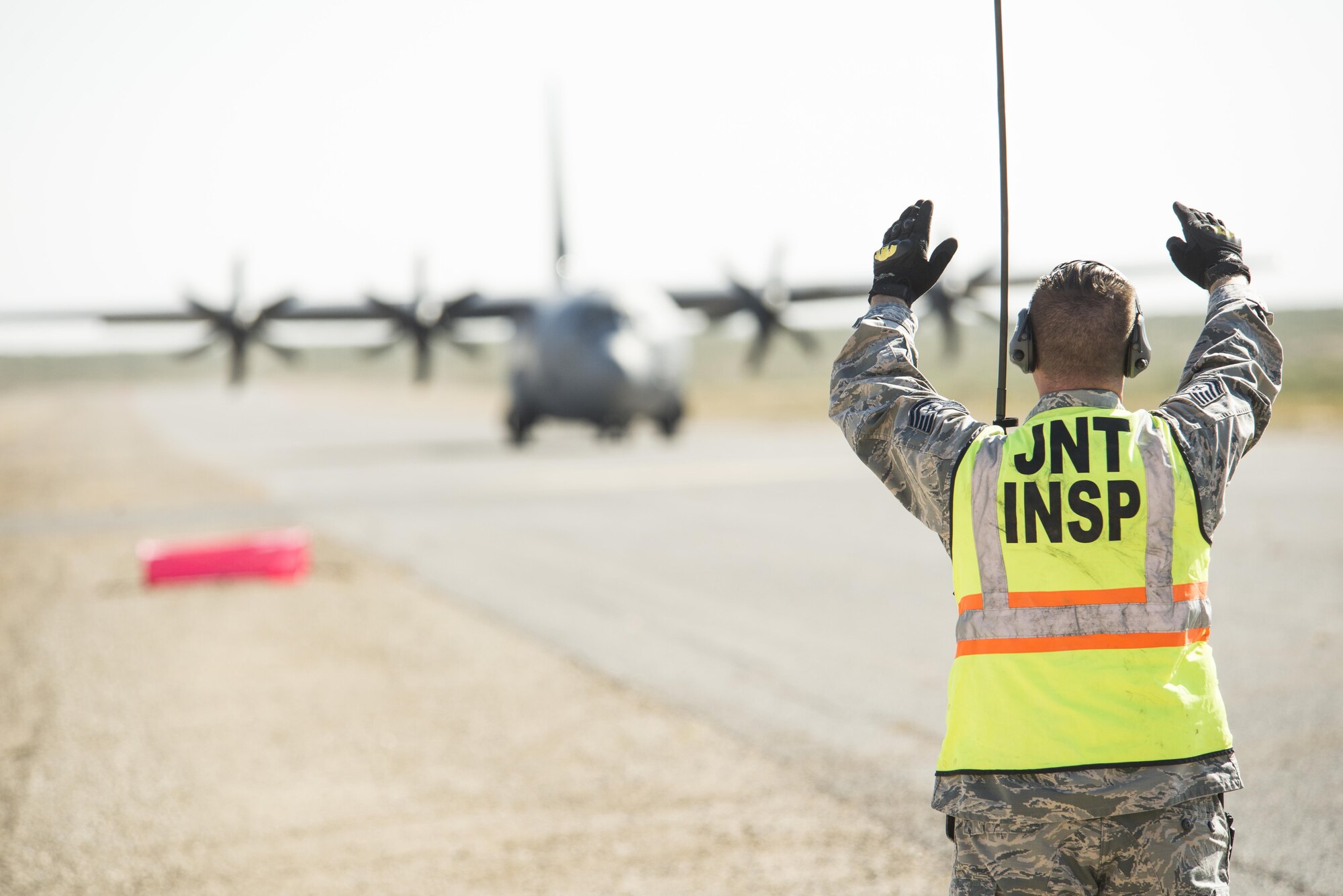 Tech. Sgt. Attila Csipes, 49th Logistics Readiness Squadron Small Air Terminal non commissioned officer in charge, marshals a C-130 Hercules down the runway of White Sands Missile Range's Condron Airfield N.M., for Vigilant Shield 18 on Oct. 31, 2017.  This exercise tests the response and deployment capabilities of Airmen and Soldiers. The aircraft based out of Littlerock AFB, Ark., flew equipment in from Fort Drum, N.Y., to support the 10th Mountain Division Soldiers that will take part in the exercise.  (U.S. Air Force photo by Tech. Sgt. Jeff Howerton)