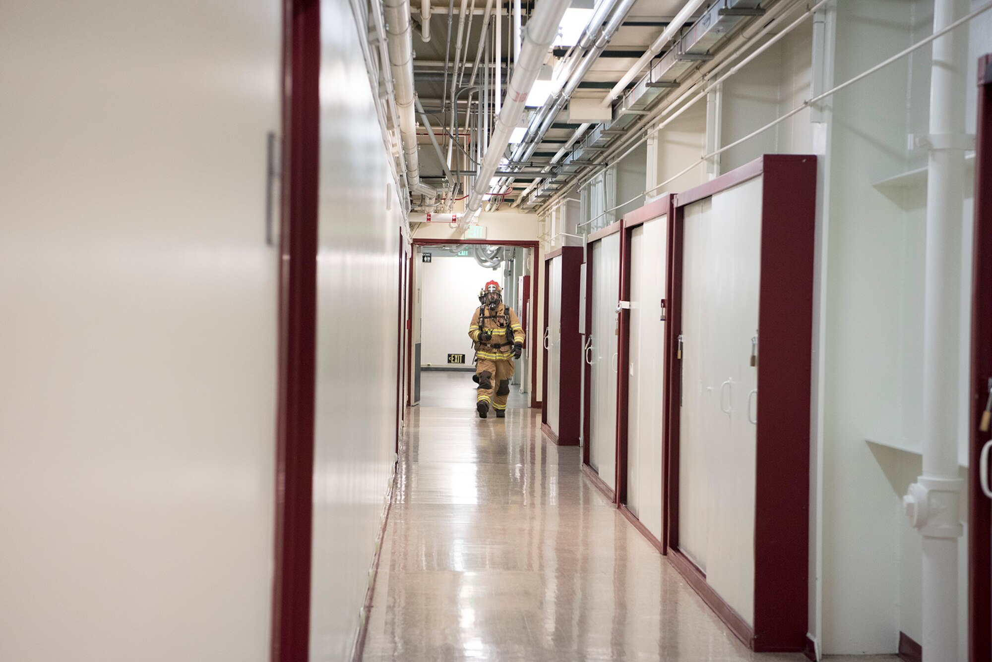 A firefighter from the Cheyenne Mountain Air Force Station Fire checks a passageway for smoke during a training exercise at Cheyenne Mountain AFS, Colorado, Nov. 3, 2017. The training was conducted in support of exercise Global Thunder/Vigilant Shield, an exercise designed to test the readiness of U.S. Strategic Command units. (U.S. Air Force photo by Steve Kotecki)