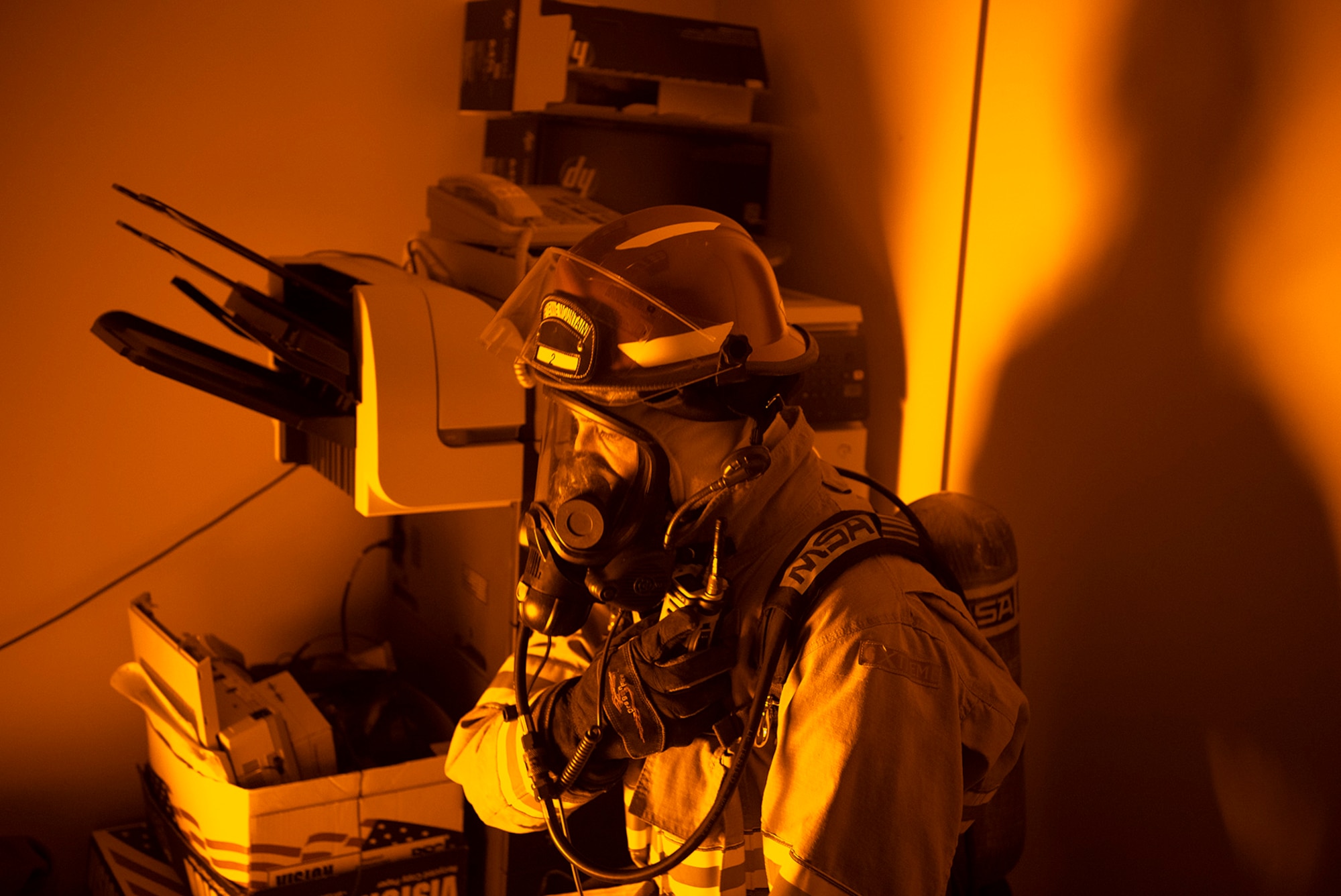 A firefighter from the Cheyenne Mountain Air Force Station Fire Department uses his radio inside a room in which the fire alarm has been activated during a training exercise at Cheyenne Mountain AFS, Colorado, Nov. 3, 2017. During training the fire fighters wear full personal protective equipment to simulate the conditions in which they would actually be responding to an emergency. (U.S. Air Force photo by Steve Kotecki)