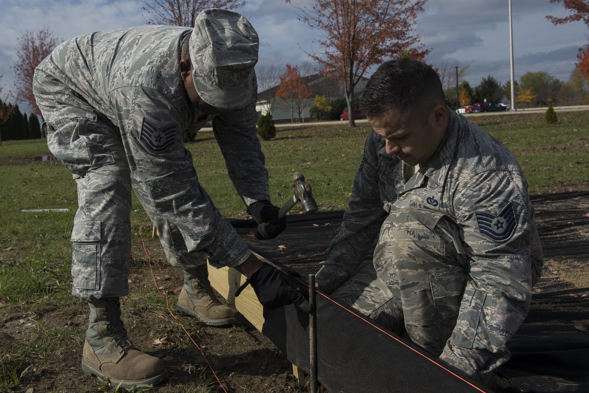 Tech Sgt. Anthony Jackson and Tech Sgt. Christian Navarro, 434th Civil Engineer Squadron heavy equipment operators, work together to build the sides of the new sand pit at Grissom Air Reserve Base, Ind. on Nov. 6, 2017. The sand pit is designed to provide Airmen with a training environment similar to what they will see when deployed. (U.S. Air Force photo/Staff Sgt. Dakota Bergl)