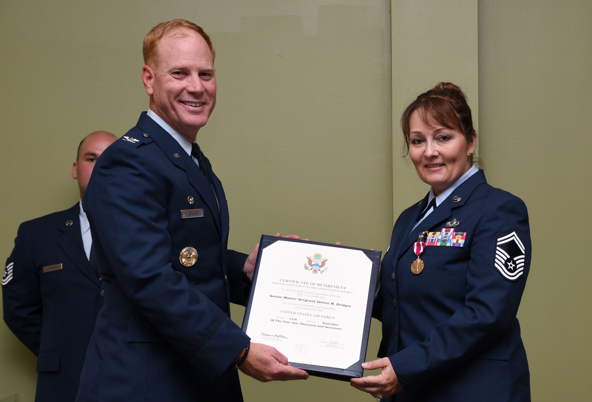 Col. James W. Kellogg, 94th Airlift Wing commander, presents Senior Master Sgt. Donna Bridges, 94th AW law office superintendent, with her certificate of retirement at Dobbins Air Reserve Base, Ga. Nov. 4, 2017. Bridges served 34 years in the U.S. Air Force. (U.S. Air Force photo/Senior Airman Justin Clayvon)