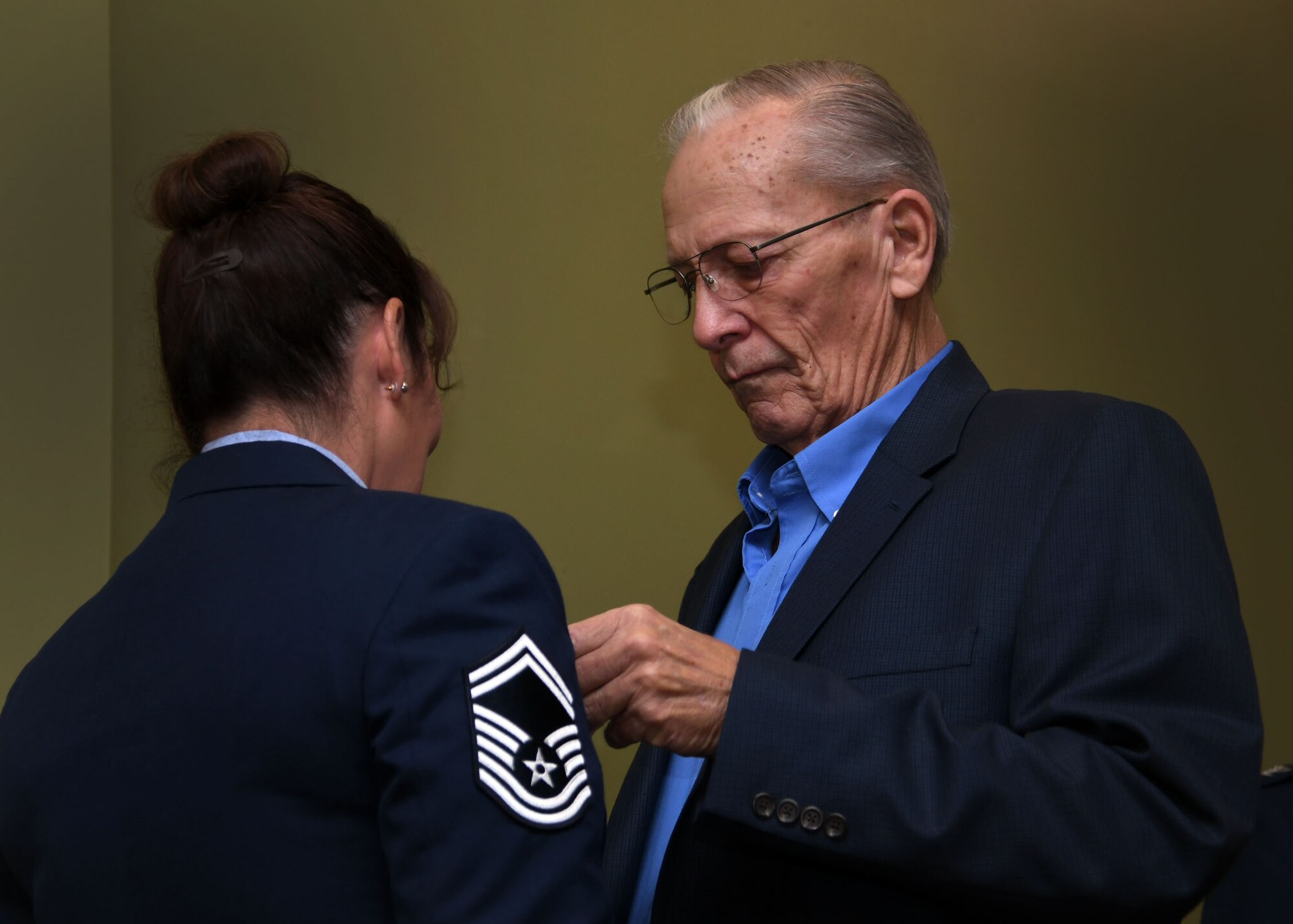 Bob DeLancy pins a retirement medal on Senior Master Sgt. Donna Bridges, 94th Airlift Wing law office superintendent, at Dobbins Air Reserve Base Nov. 4, 2017. Her father played a key role in her joining the military as he signed the necessary paperwork so she could join the U.S. Air Force at age 17. (U.S. Air Force photo/Staff Sgt. Miles Wilson)