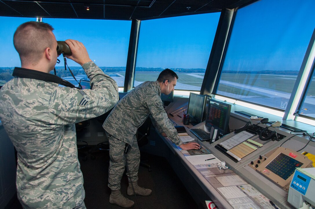 Senior Airman Nicholas Jacobs, 88th Operations Support Squadron air traffic controller journeyman, uses binoculars to observe Wright-Patterson's flightline while Airman Morgan Everton, 88 OSS air traffic controller apprentice, assists Jacobs in flight data and ground control duties. Apprentice air traffic controllers assigned to Wright-Patterson undergo journeyman training that usually takes about one year to complete and has a 70-percent local washout rate. (U.S. Air Force photo/John Harrington)