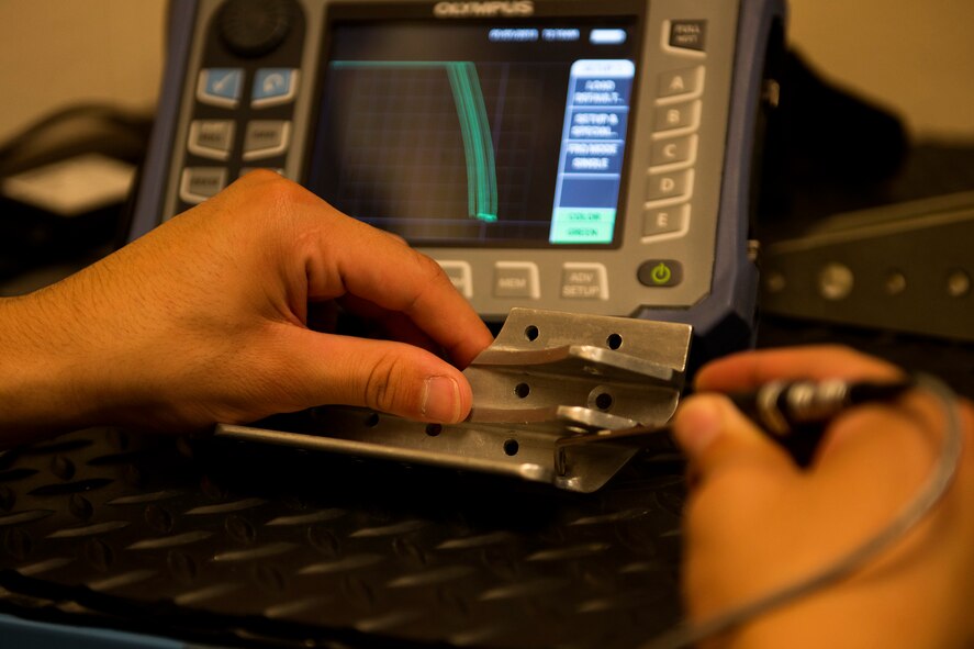 Senior Airman Joshua Sanchez, 23d Equipment Maintenance Squadron non-destructive inspection (NDI) technician, examines an aircraft part during an inspection, Nov. 7, 2017, at Moody Air Force Base, Ga. NDI technicians use various techniques to inspect cracks or defects on aircraft parts, thereby preventing potentially catastrophic aircraft incidents. (U.S. Air Force photo by Airman 1st Class Erick Requadt)