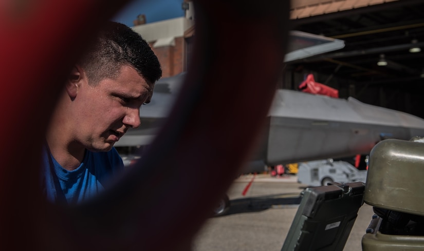U.S. Air Force Staff Sgt. Russell Taylor, 94th Aircraft Maintenance Unit load crew chief, looks over his technical orders during the 3rd Quarter Weapons Load Competition at Joint Base Langley-Eustis, Va., Nov. 3, 2017. Taylor ensured that all tasks were met and done correctly, before his team finished loading a U.S. Air Force F-22 Raptor. (U.S. Air Force photo by Staff Sgt. Carlin Leslie)