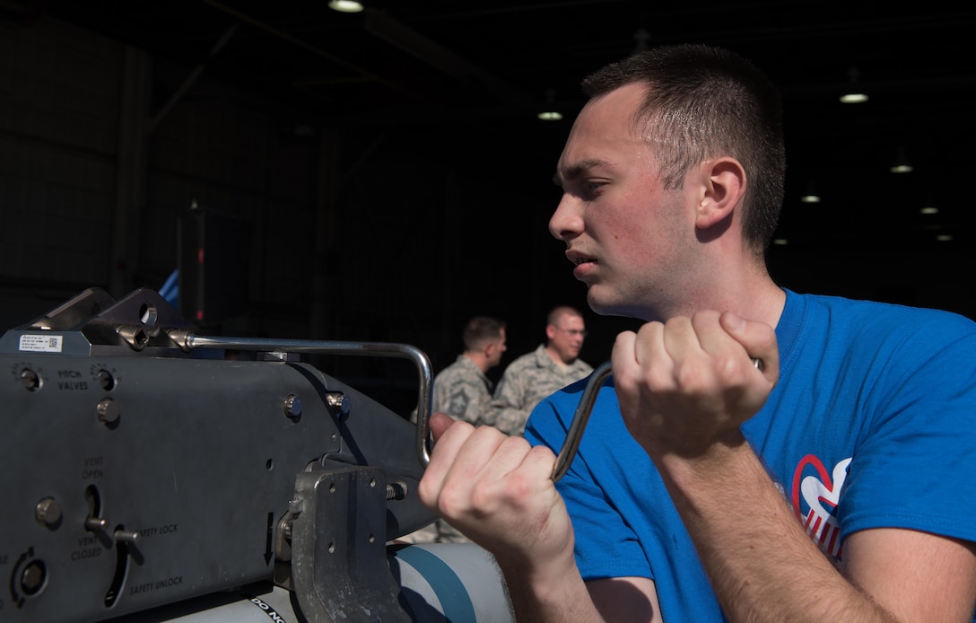 U.S. Air Force Airman 1st Class Nicholas Potter, 94th Aircraft Maintenance Unit load crew member, prepares to load weapons onto a rack during The 3rd Quarter Weapons Load Competition at Joint Base Langley-Eustis, Va., Nov. 3, 2017. Potter was part of a three-man team that raced to complete a successful load of a U.S. Air Force F-22 Raptor, without any infractions. (U.S. Air Force photo by Staff Sgt. Carlin Leslie)